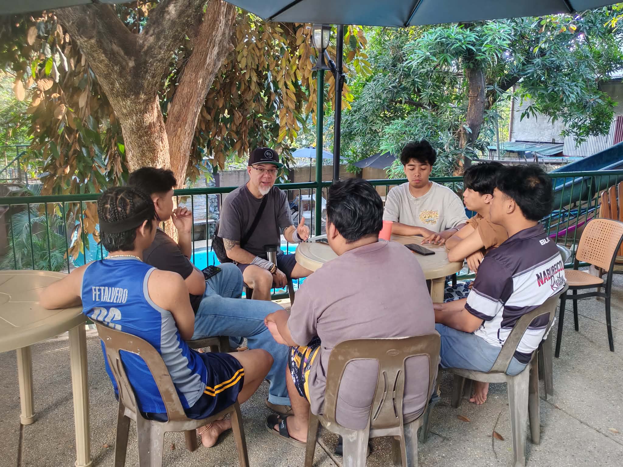 Mission team gathered in conversation around an outdoor table